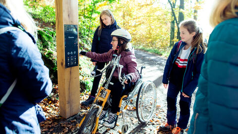 Personen bedienen Zwitscherbox an Wanderweg