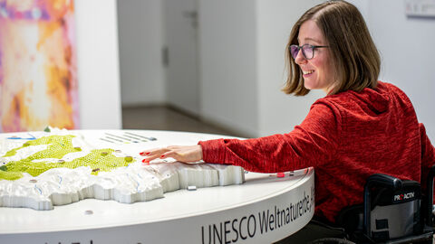 Ausstellung zum Mitmachen Besucherin bedient interaktive Ausstellung im Nationalparkzentrum
