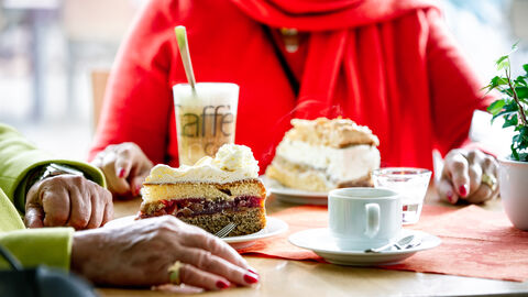 Kaffeezeit Zwei Menschen sitzen am Tisch bei Kaffee und Kuchen