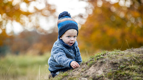 Kind tastet über Baumstamm