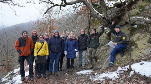 Mehrere Menschen stehen auf einem Waldweg
