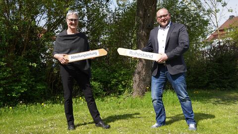 Zwei Personen überreichen sich gegenseitig einen Staffelstab