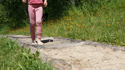 Kind läuft über Barfußpfad