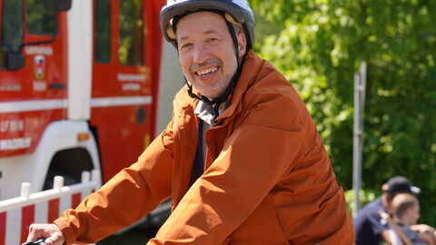 Person sitzt auf Fahrrad und trägt Helm