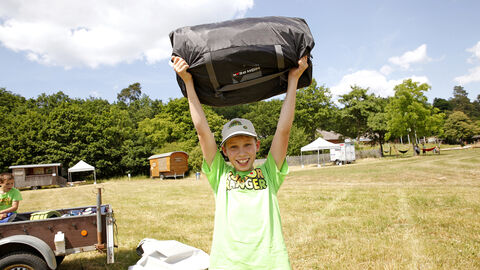 Ein Kind hält eine Tasche über den Kopf