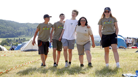 Mehrere Menschen laufen gemeinsam über eine Wiese
