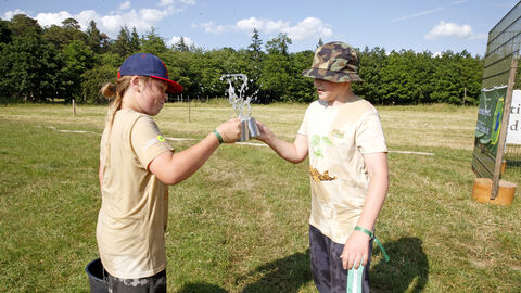 Zwei Kinder stoßen mit Metallbechern an