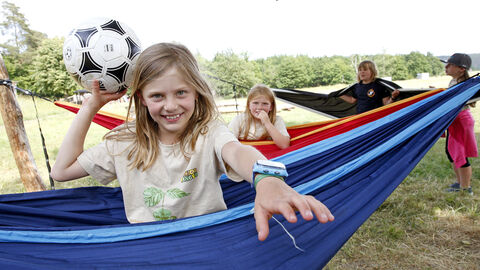 Kinder sitzen in Hängematten