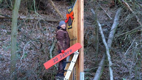 Die Nationalpark-Eule bekommt eine rote Schleife aus Holz.