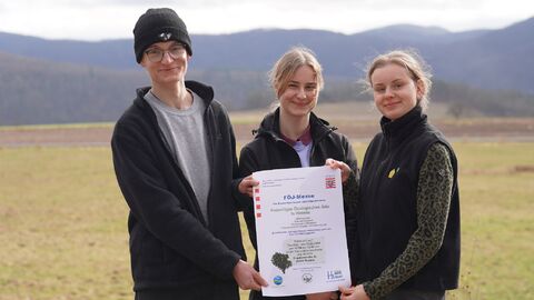 Personen halten ein Plakat in die Kamera