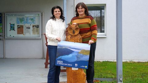 Zwei Personen präsentieren den Nationalpark-Wandkalender 2025