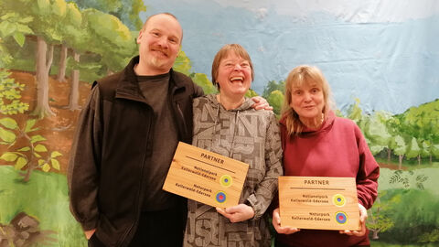 Drei Personen erhalten ein Zertifikat