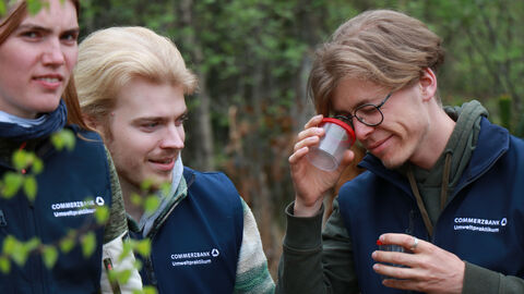 Menschen untersuchen Tiere in einer Becherlupe