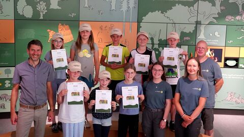 In der KellerwaldUhr: Die Junior Ranger der Kellerwaldschule Frankenau freuen sich über ihre Zertifizierung - Nationalparkleiter Manuel Schweiger (1.v.l.) überreichte mit den betreuenden Nationalpark-Rangern Alisa Fischer (4.v.r.), Anne Wöllenstein (2.v.r.) und Volker Nagel (1.v.r.) den Kindern ihre Urkunden. Gruppenfoto Junior Ranger Frankenau