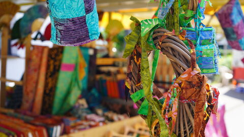 Bunter Marktstand Einblick in den Batikstand, an dem es Kleidung und Nützliches aus Stoff gab