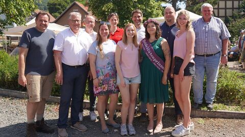 Eine Gruppe Menschen steht in der Sonne und lächelt in die Kamera