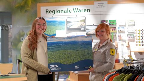 Zwei Personen präsentieren einen Wandkalender