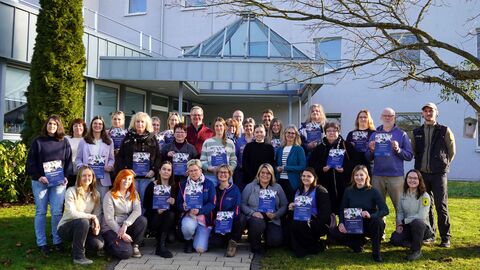 Mehrere Personen halten Urkunden in die Kamera