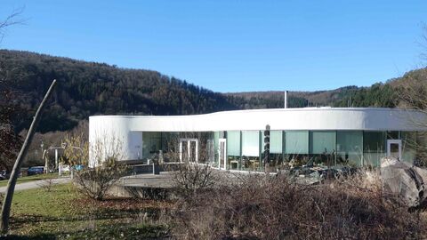 Außenansicht des futuristischen Gebäudes des NationalparkZentrums - im Vordergrund sind blattlose Büsche zu sehen.