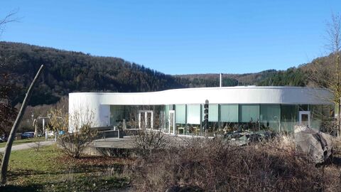 Außenansicht des futuristischen Gebäudes des NationalparkZentrums - im Vordergrund mit blattlosen Büschen.